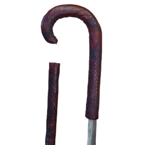 66 - Somali stick sword, dark red leather, crook style handle, about good very fine. BUYER MUST COLLECT.
