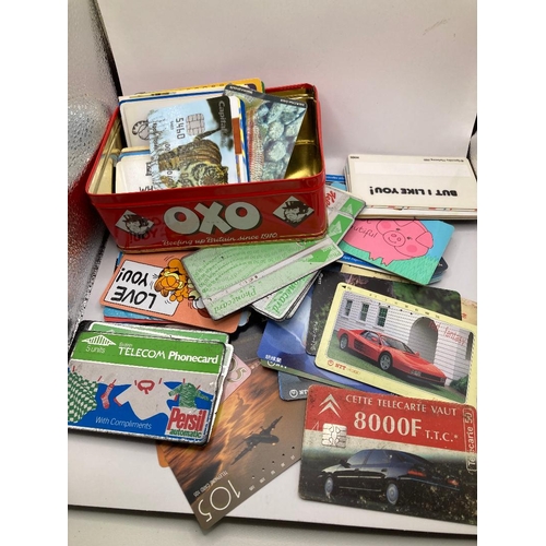 35 - OXO tin full of old phone cards, mostly pictorial ones UK and Foreign