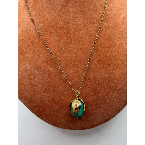 21 - Jewellery : Green stone pendant with leaf pattern surround, marked 14K and test as such, on a yellow... 