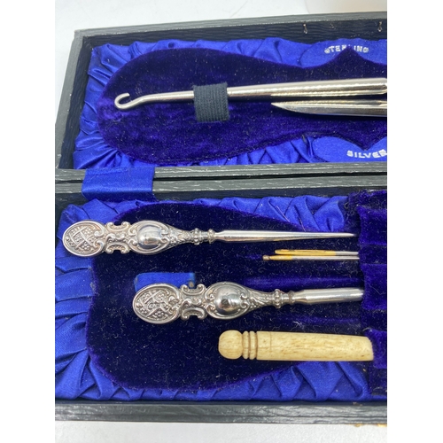 121 - A case with silver sewing items, a silver handled button hook, crochet hook & sewing point, Birmingh... 