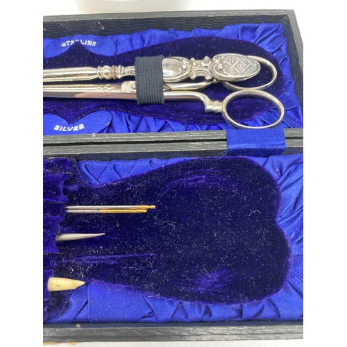 121 - A case with silver sewing items, a silver handled button hook, crochet hook & sewing point, Birmingh... 