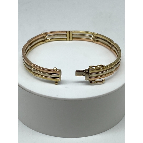 3 - A 9ct tricolour gold bangle, double figure 8 safety catches, hallmarked 9ct, 16.4 grams approx weigh... 