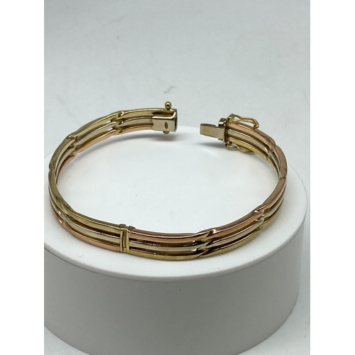 3 - A 9ct tricolour gold bangle, double figure 8 safety catches, hallmarked 9ct, 16.4 grams approx weigh... 