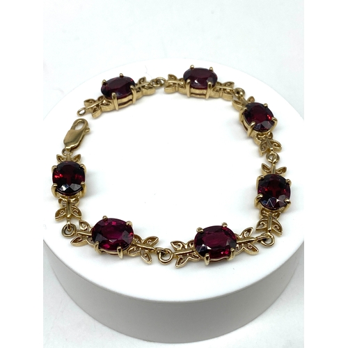 62 - A 9ct yellow gold red stone bracelet, 7 1/2 inches long, 16.8 grams in weight approx