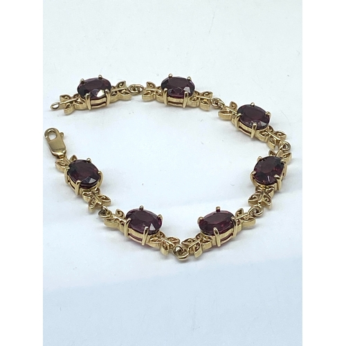 62 - A 9ct yellow gold red stone bracelet, 7 1/2 inches long, 16.8 grams in weight approx