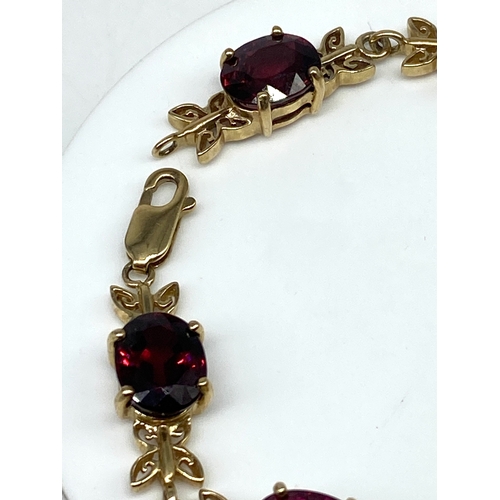 62 - A 9ct yellow gold red stone bracelet, 7 1/2 inches long, 16.8 grams in weight approx