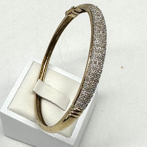 92 - A 9ct yellow gold diamond encrusted bangle, hallmarked 0.50ct diamonds in the bangle, hallmarked 375... 