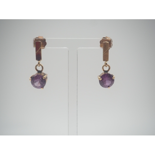 501 - A pair of 14ct yellow gold purple glass set drop earrings, round faceted glass 7.7mm each, claw set,... 