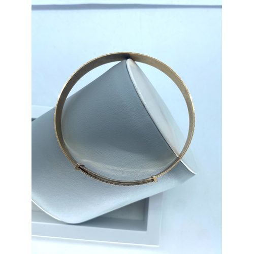 21 - A 9ct yellow gold bangle, adult size expanding bangle, 8mm wide, 8 inches round and 1 1/2 inches exp... 