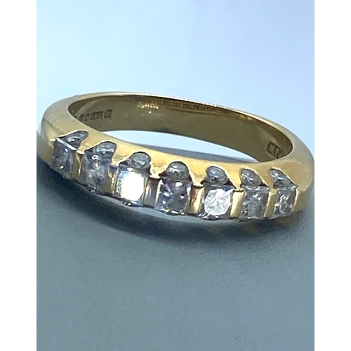 24 - An 18ct yellow gold diamond eternity ring, top side of eternity band has princess cut diamonds appro... 