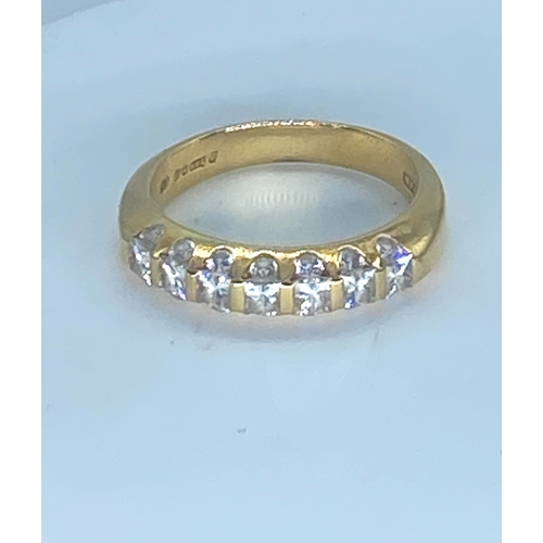 24 - An 18ct yellow gold diamond eternity ring, top side of eternity band has princess cut diamonds appro... 