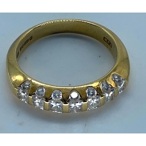 24 - An 18ct yellow gold diamond eternity ring, top side of eternity band has princess cut diamonds appro... 