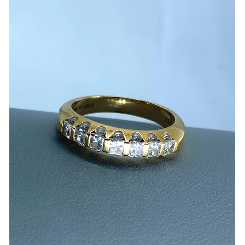 24 - An 18ct yellow gold diamond eternity ring, top side of eternity band has princess cut diamonds appro... 