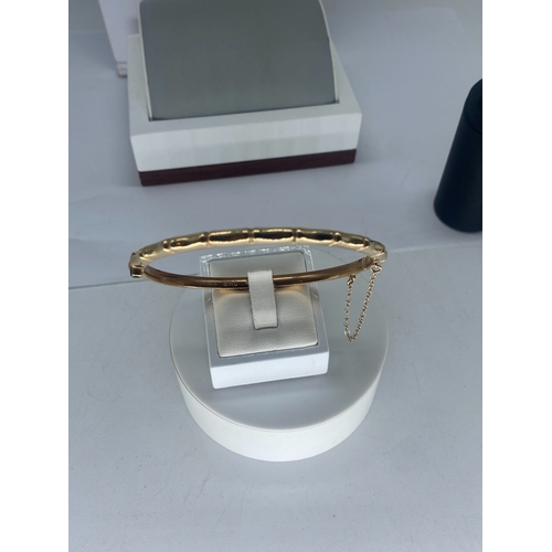 92 - A 9ct yellow gold bangle, 7.6 grams in weight approx, with a safety chain, no signs of damage, fully... 