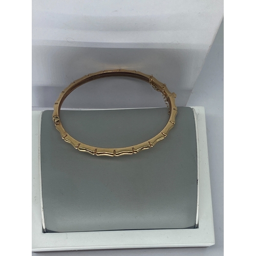 92 - A 9ct yellow gold bangle, 7.6 grams in weight approx, with a safety chain, no signs of damage, fully... 