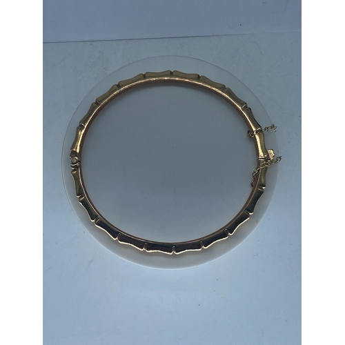 92 - A 9ct yellow gold bangle, 7.6 grams in weight approx, with a safety chain, no signs of damage, fully... 