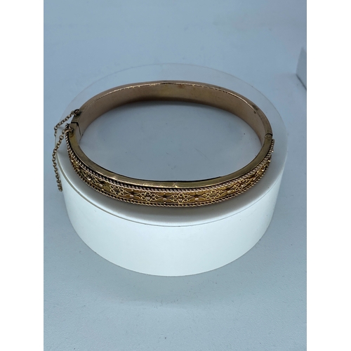 113 - A Victorian 9ct rose gold lace design bangle, has a safety chain, fully hallmarked, there are some a... 