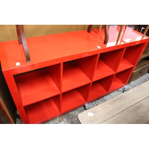 152 - A stylish red lacquer eight division storage trolley.