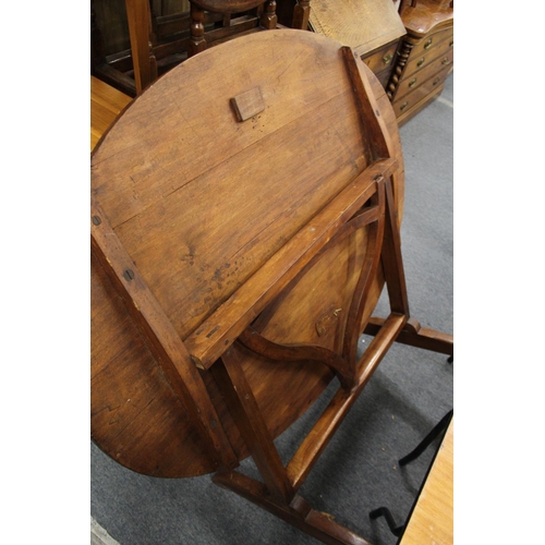 222 - A continental oval walnut tilt top trestle end table.