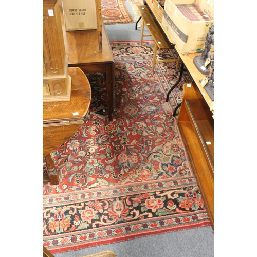 306 - A large Persian design carpet, red ground with broad floral decoration (some wear).