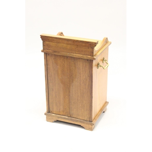 1008 - A VICTORIAN OAK COAL PURDONIUM, with carved decoration and brass handles. 2ft 2ins high.