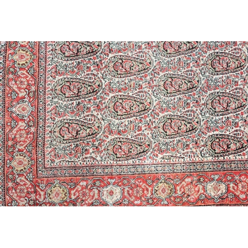 1043 - A PERSIAN SENNA RUG, early 20th century, beige ground with Boteh decoration within a red ground bord... 