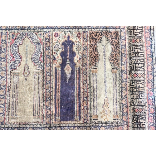 1047 - AN UNUSUAL PERSIAN PRAYER RUG, the central panel with eight arches and hanging lamps, within a geome... 