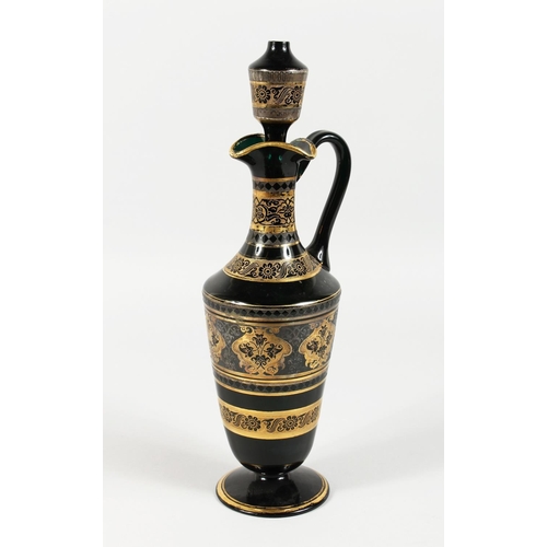 1062 - A CONTINENTAL DARK GREEN GLASS EWER AND STOPPER, with etched and gilded decoration. 14ins high.