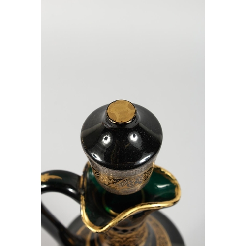 1062 - A CONTINENTAL DARK GREEN GLASS EWER AND STOPPER, with etched and gilded decoration. 14ins high.