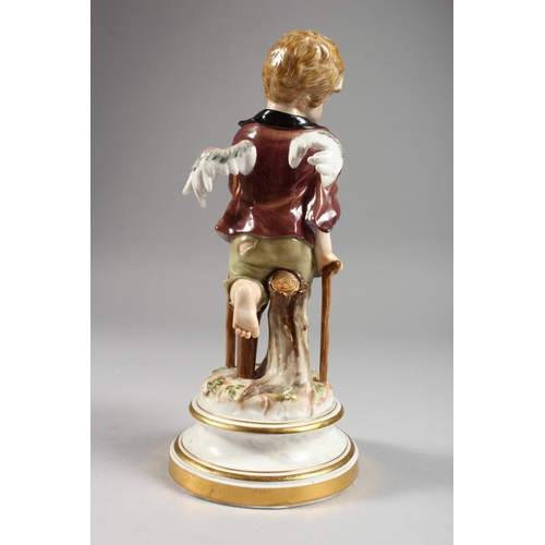 1118 - A MEISSEN PORCELAIN FIGURE OF A CHERUB holding a hat and walking with a stick. Cross swords mark in ... 