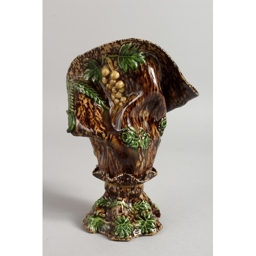 1128 - A SMALL MAJOLICA BROWN GLAZED VASE with fruiting vines. 7ins high.