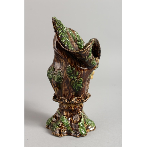 1128 - A SMALL MAJOLICA BROWN GLAZED VASE with fruiting vines. 7ins high.