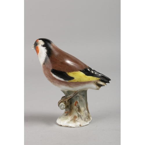 1140 - A 19TH CENTURY MEISSEN BIRD on a branch. Cross swords mark in blue.  3.5ins high.