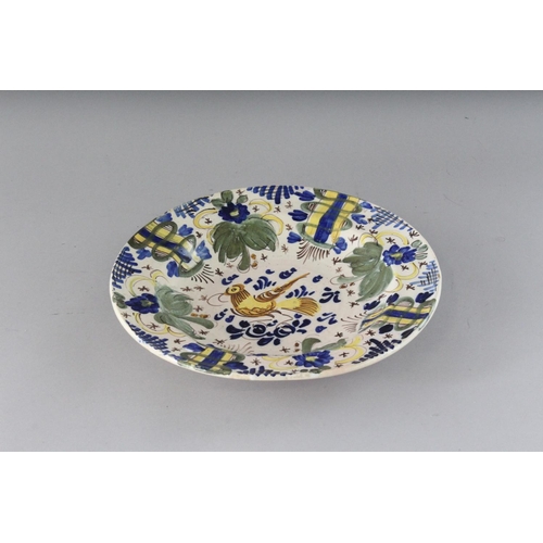 1153 - AN EARLY SPANISH FAIENCE DISH in mainly blue and yellow. 10.5ins diameter.