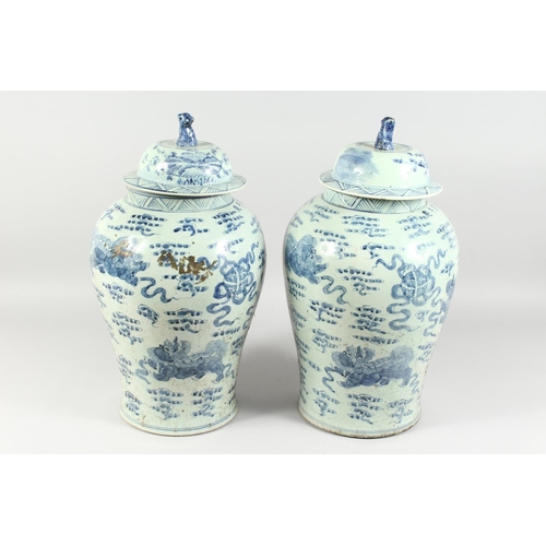 1161 - A PAIR OF 20TH CENTURY CHINESE BLUE AND WHITE BALUSTER SHAPE TEMPLE JARS AND COVERS, painted with li... 