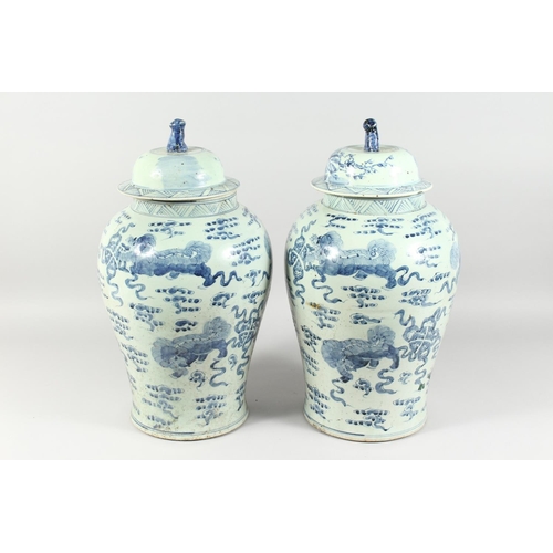 1161 - A PAIR OF 20TH CENTURY CHINESE BLUE AND WHITE BALUSTER SHAPE TEMPLE JARS AND COVERS, painted with li... 