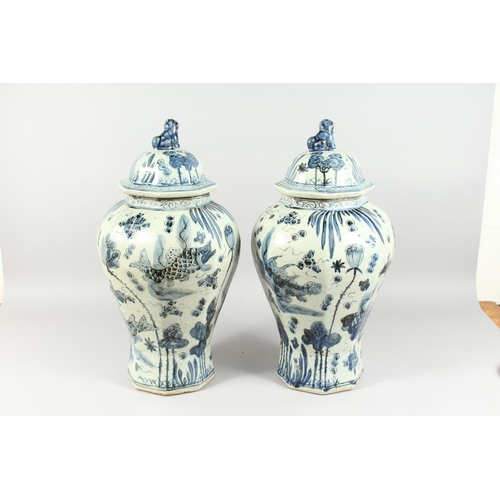 1162 - A PAIR OF 20TH CENTURY CHINESE BLUE AND WHITE BALUSTER SHAPE TEMPLE JARS AND COVERS, painted with fi... 