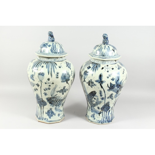 1162 - A PAIR OF 20TH CENTURY CHINESE BLUE AND WHITE BALUSTER SHAPE TEMPLE JARS AND COVERS, painted with fi... 