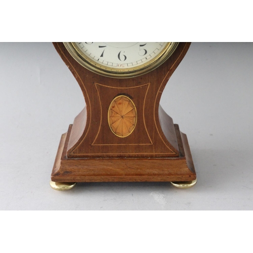 1192 - A SMALL EDWARDIAN MAHOGANY INLAID BALLOON SHAPED CLOCK on four brass ball feet. 8.5ins high.