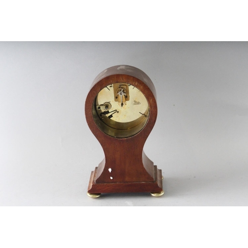 1192 - A SMALL EDWARDIAN MAHOGANY INLAID BALLOON SHAPED CLOCK on four brass ball feet. 8.5ins high.