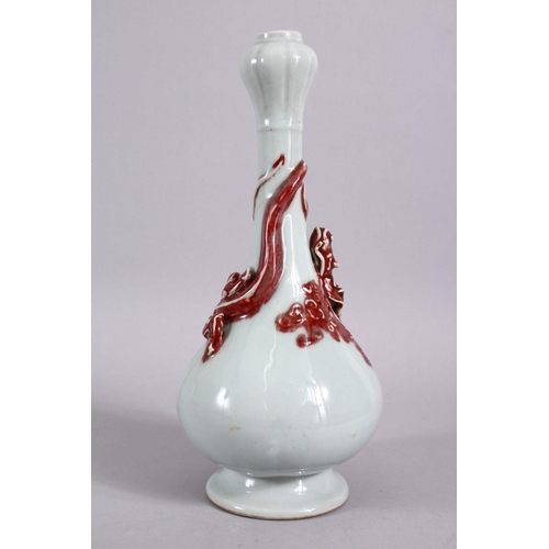 102 - A CHINESE COPPER RED GARLIC HEAD PORCELAIN CHILONG VASE, the monochrome body with iron red moulded c... 