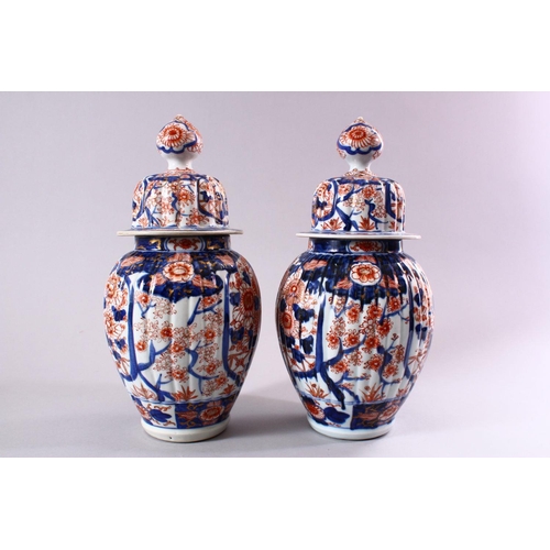 11 - A PAIR OF JAPANESE MEIJI PERIOD IMARI PORCELAIN VASES AND COVERS, with ribbed body's, and panels of ... 