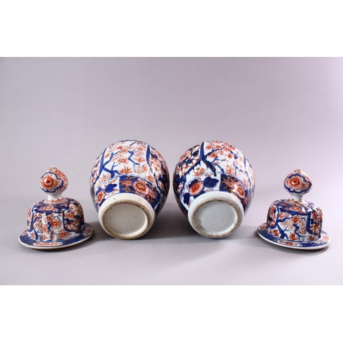 11 - A PAIR OF JAPANESE MEIJI PERIOD IMARI PORCELAIN VASES AND COVERS, with ribbed body's, and panels of ... 