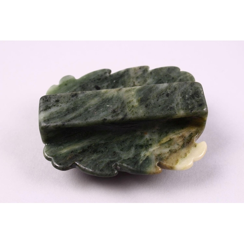 119 - A CHINESE CARVED JADE BELT BUCKLE / DECORATION OF A RECUMBENT KYLIN, upon a leaf, 6.5cm.