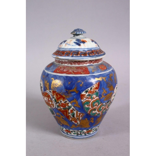 126 - AN 18TH CENTURY JAPANESE BLUE, WHITE AND IRON RED PORCELAIN ARITA JAR & COVER, with landscape views ... 