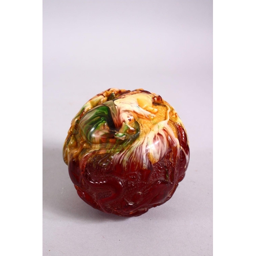 153 - A CHINESE CARVED BAKELITE OR CHERRY AMBER ZODIAC BALL, carved with animals, 9cm diameter.