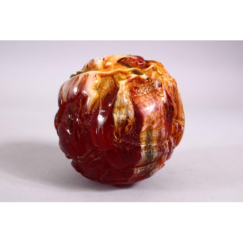 153 - A CHINESE CARVED BAKELITE OR CHERRY AMBER ZODIAC BALL, carved with animals, 9cm diameter.