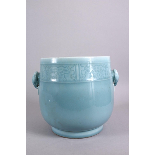 161 - A CHINESE CELADON GROUND TWIN HANDLE PORCELAIN POT, with carved ruyi and chilong decoration, the bas... 