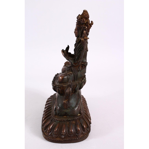 164 - A TIBETAN BRONZE FIGURE OF BUDDHA / DEITY, in a seated position upon a recumbent lion dog, upon a st... 