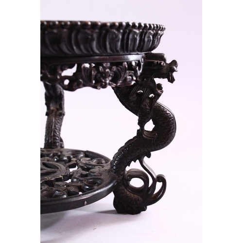 18 - A GOOD CHINESE CARVED HARDWOOD STAND, with inlaid marble top, 22cm high, 30cm diameter.